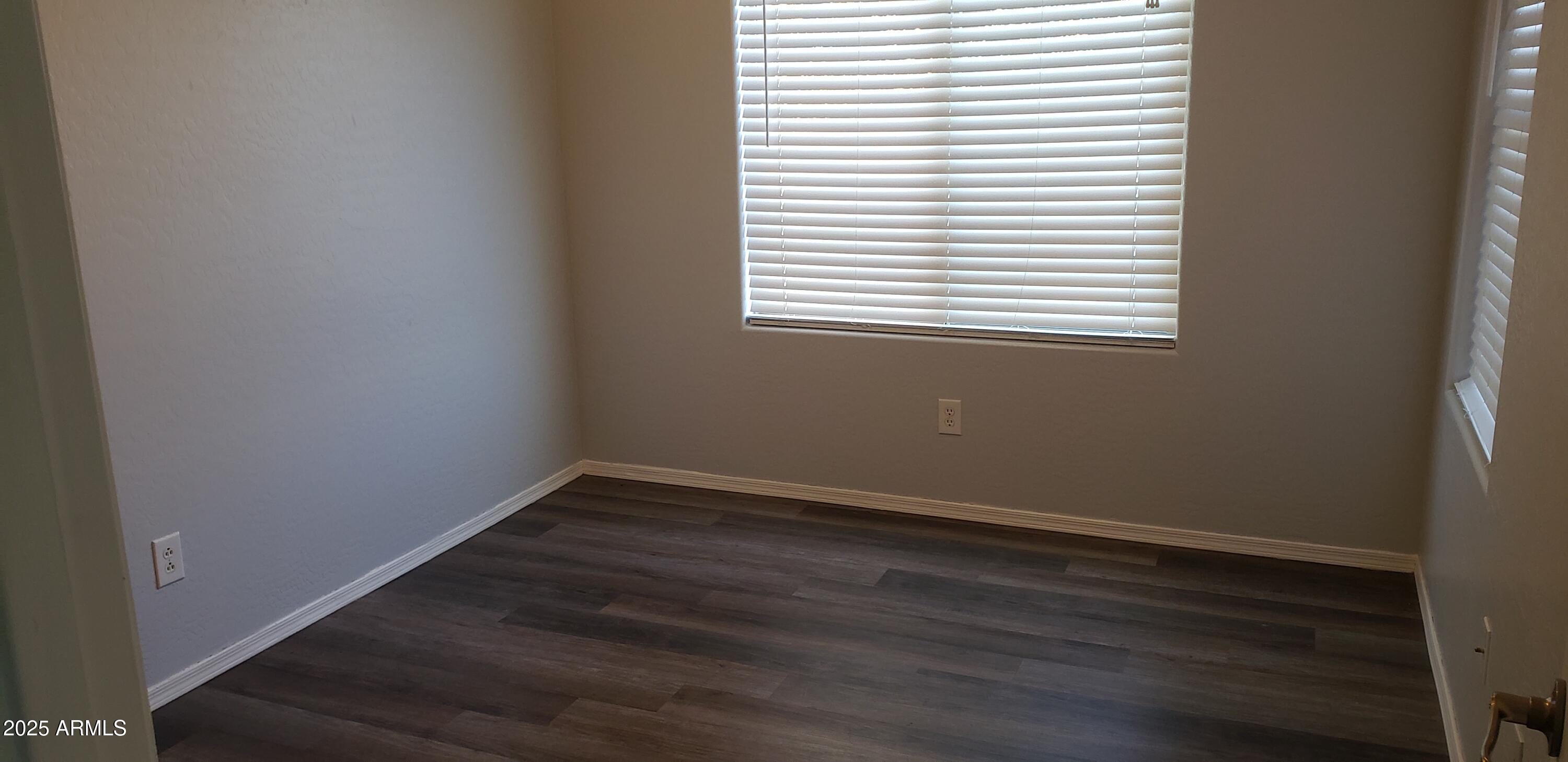 4631 West Shumway Farm Road Laveen, AZ 85339 - Photo 7 of 16 an empty room with wooden floor and a window