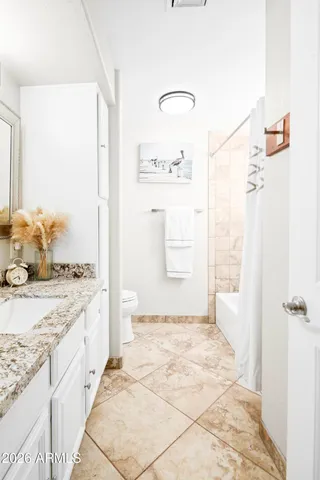a bathroom with a granite countertop sink a mirror and a shower