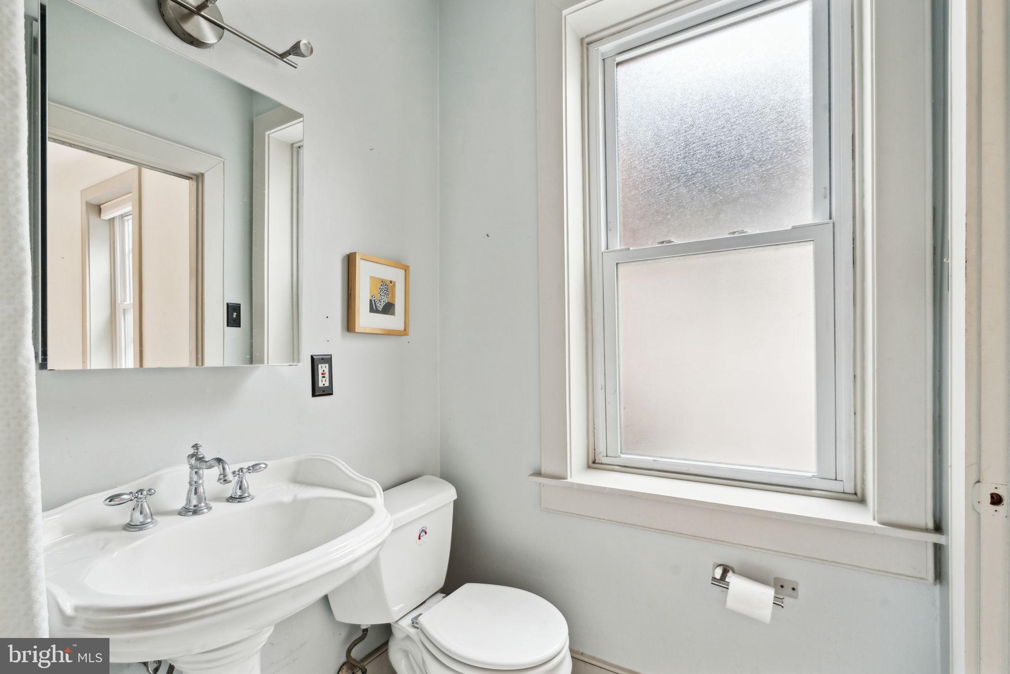 2206 Wallace Street Philadelphia, PA 19130 - Photo 13 of 38 a bathroom with a toilet sink and mirror