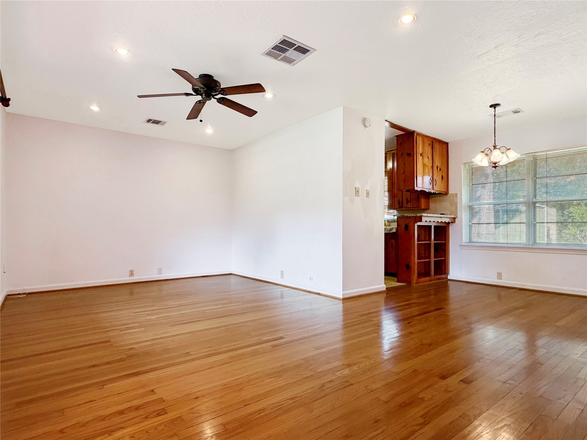 3018 Attridge Road Houston, TX 77018 - Photo 4 of 29 an empty room with wooden floor a ceiling fan and windows