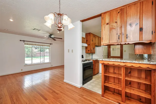 a kitchen with granite countertop wooden cabinets a sink and a window