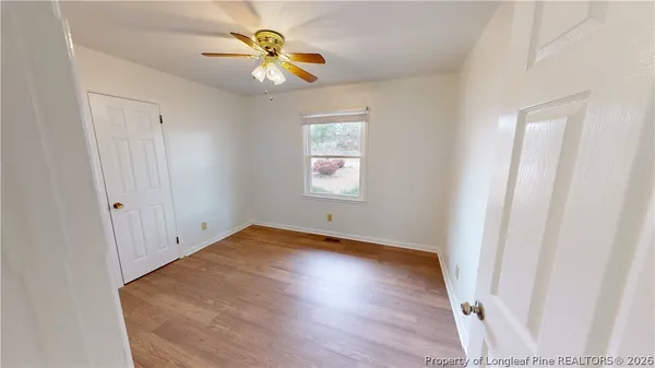 an empty room with wooden floor and window