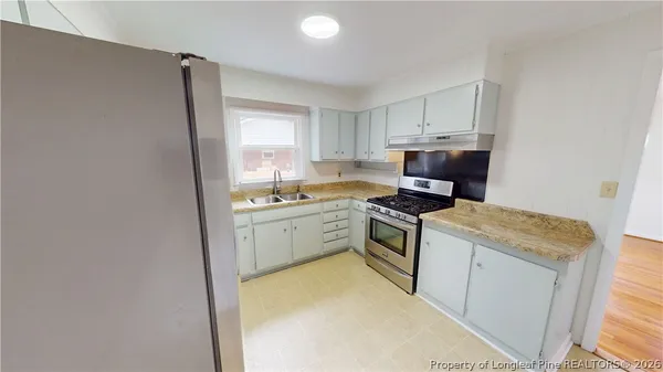a kitchen with a stove top oven and sink