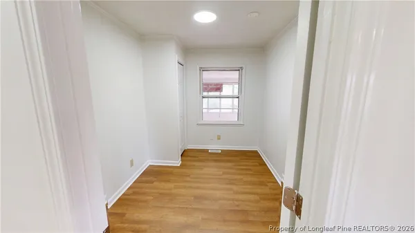a view of a room with wooden floor and window