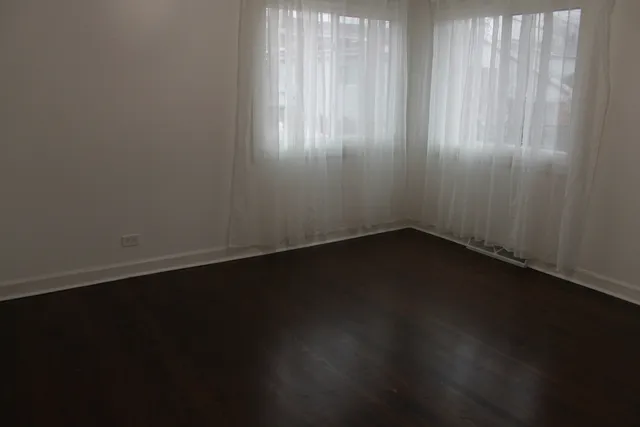 a view of a small space with wooden floor and a window