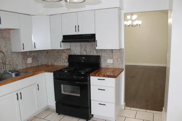a kitchen with granite countertop white cabinets and black appliances