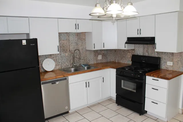 a kitchen with granite countertop a sink stove and cabinets