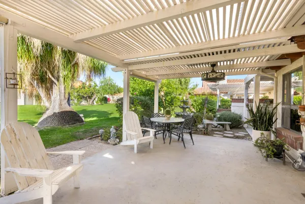 a patio with table and chairs and potted plants