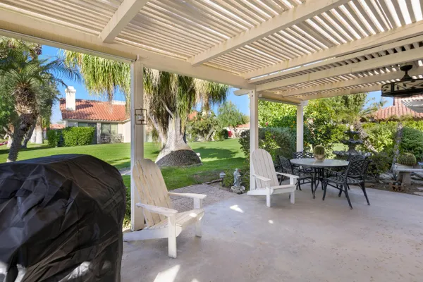 a view of a patio with a table chairs and a backyard