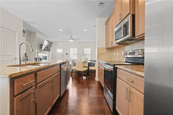 a kitchen with stainless steel appliances granite countertop lots of counter top space and cabinets