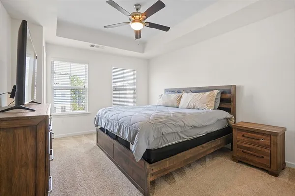 a spacious bedroom with a bed and a chandelier