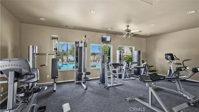 a living room with furniture gym equipment and large windows