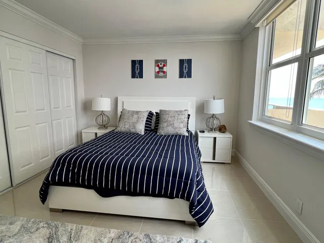 a bedroom with a bed and a large window