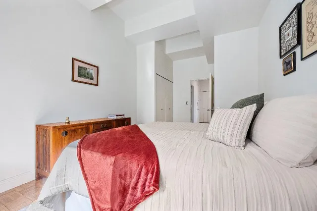 a bedroom with a bed and a lamp with the wooden floor
