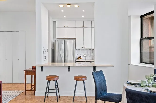 a kitchen with stainless steel appliances kitchen island granite countertop a table chairs and wooden cabinets
