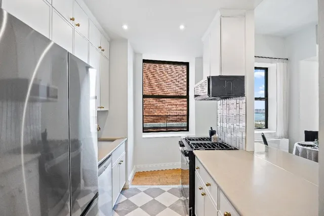 a kitchen with a refrigerator a sink and a stove top oven