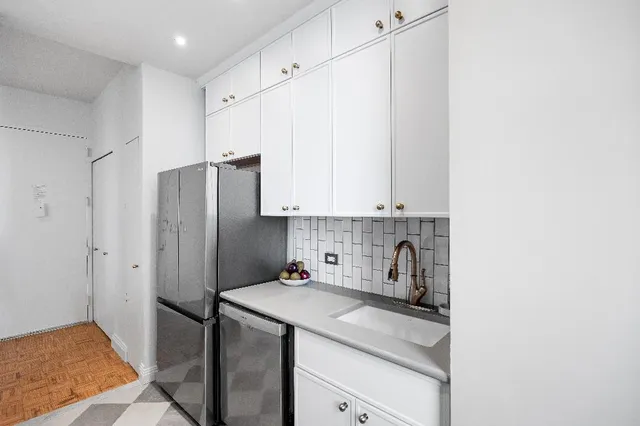 a kitchen with stainless steel appliances a refrigerator sink and cabinets