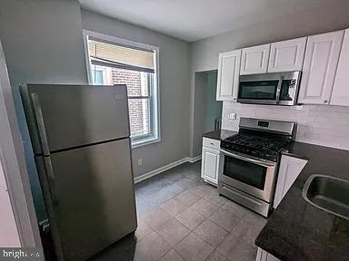 3175 Tulip Street Philadelphia, PA 19134 - Photo 2 of 12 a kitchen with a refrigerator stove and microwave