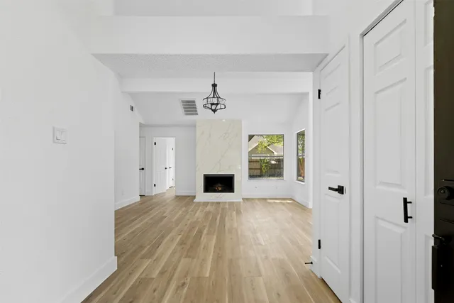 a view of a livingroom with wooden floor a fireplace and window