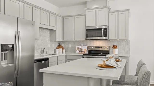 a kitchen with white cabinets and black appliances