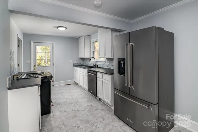 a kitchen with stainless steel appliances granite countertop a refrigerator stove and sink