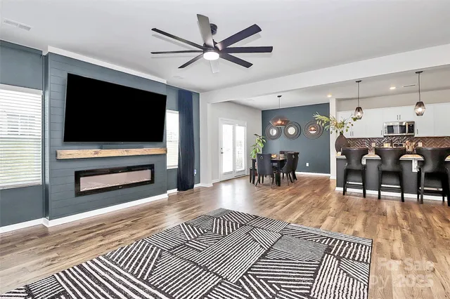 a living room with furniture a flat screen tv and kitchen view