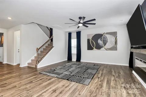 a view of a livingroom with wooden floor and a ceiling fan