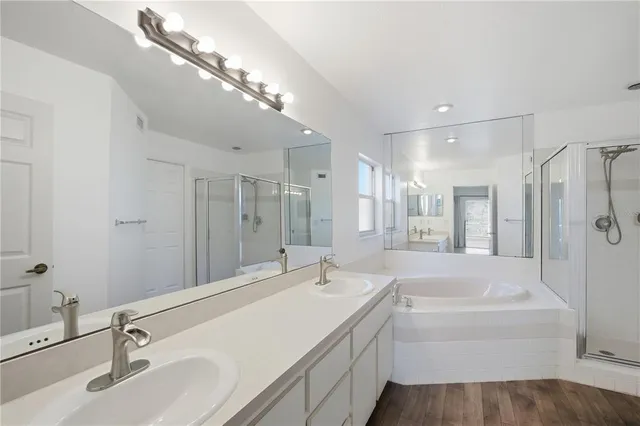 a bathroom with a tub a sink and mirror