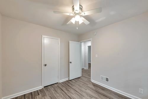551 Wimbledon Road Northeast, Unit B Atlanta, GA 30324 - Photo 19 of 20 an empty room with wooden floor and ceiling fan