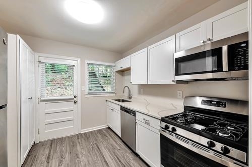 551 Wimbledon Road Northeast, Unit B Atlanta, GA 30324 - Photo 4 of 20 a kitchen with granite countertop cabinets appliances and a window
