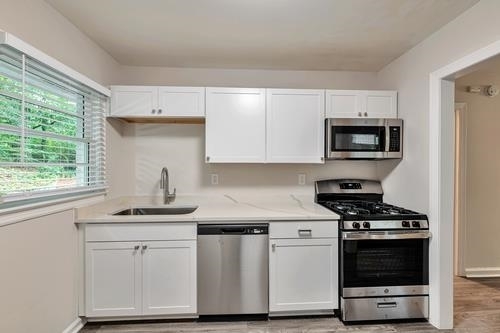 551 Wimbledon Road Northeast, Unit B Atlanta, GA 30324 - Photo 5 of 20 a kitchen with white cabinets appliances and window