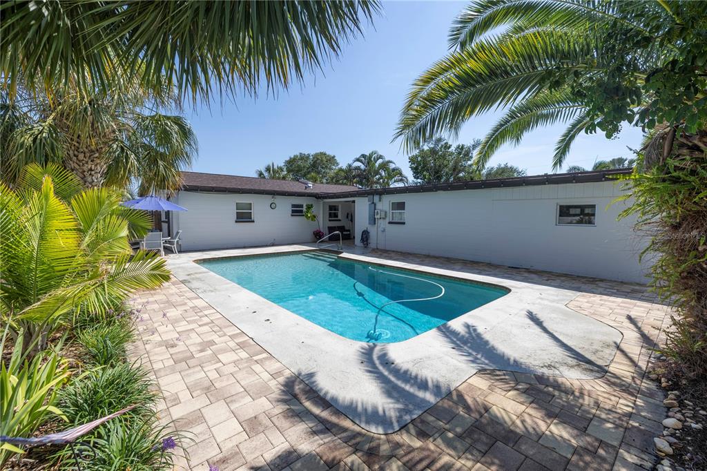 a house with a swimming pool and trees in the background