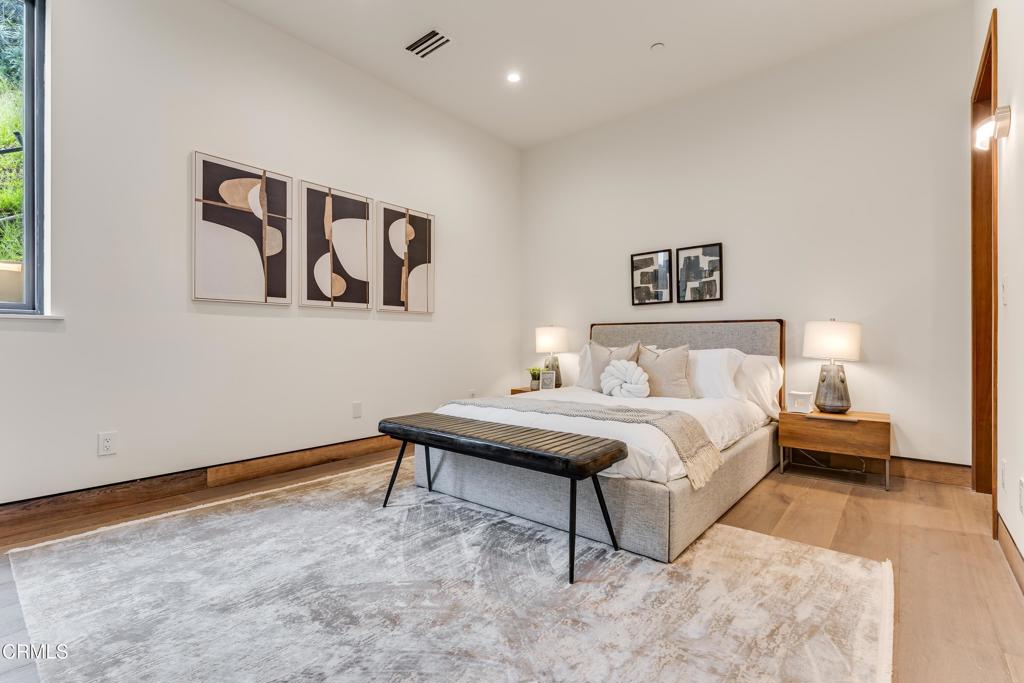 12480 Viewcrest Road Los Angeles, CA 91604 - Photo 44 of 69 a spacious bedroom with a bed and a table in it