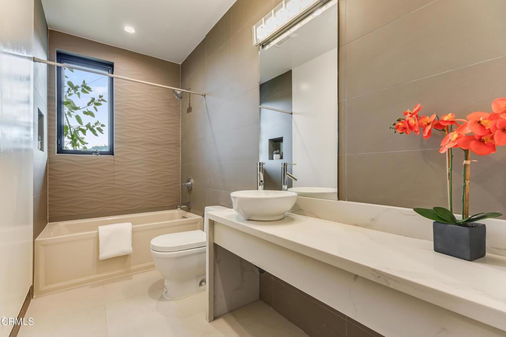 12480 Viewcrest Road Los Angeles, CA 91604 - Photo 52 of 69 a bathroom with a granite countertop sink a toilet and a mirror