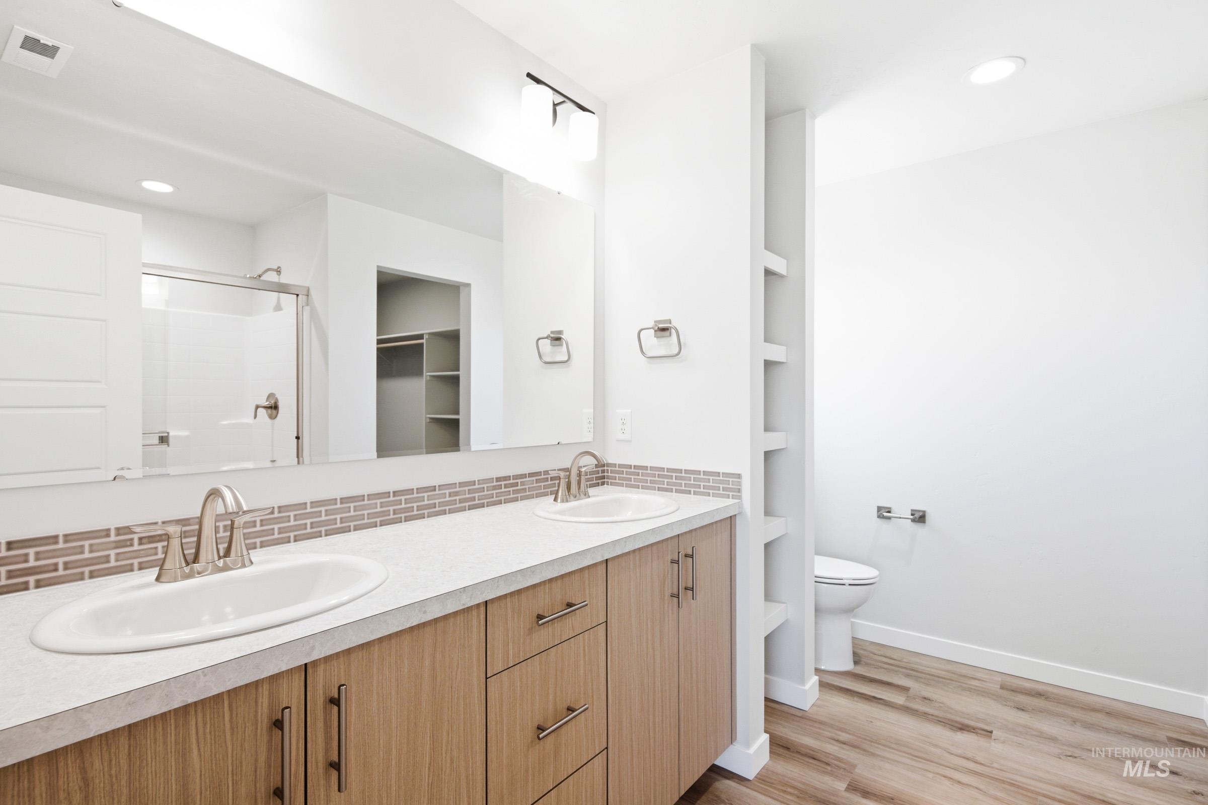 12817 Decatur Street Nampa, ID 83651 - Photo 17 of 19 Dual vanity featuring wood-finish cabinetry and brushed nickel hardware