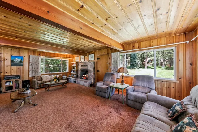 a living room with furniture a fireplace and a large window