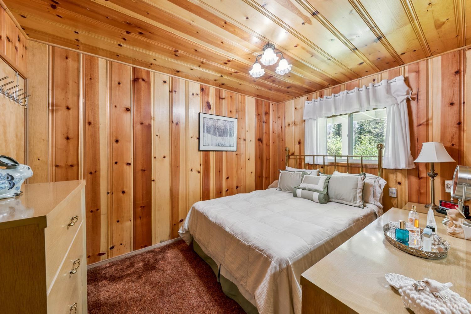 7075 Mount Ralston Road Twin Bridges, CA 95735 - Photo 21 of 26 a bedroom with a bed a lamp and a large window