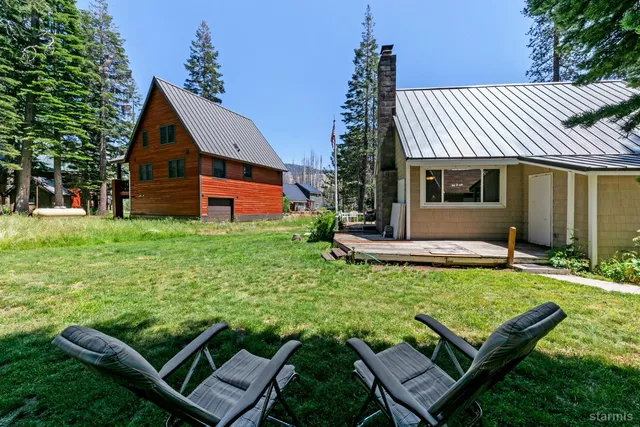 a view of a house with backyard and sitting area