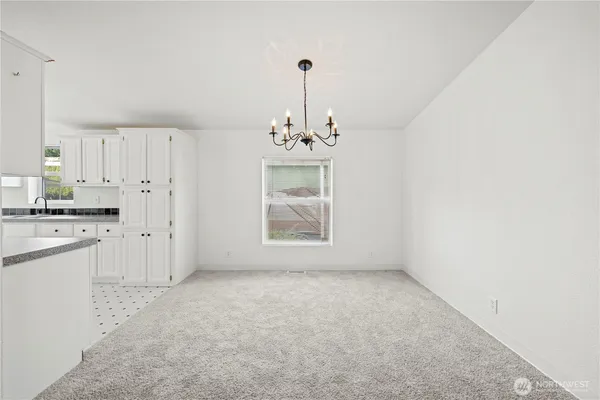 a big room with chandelier and white walls