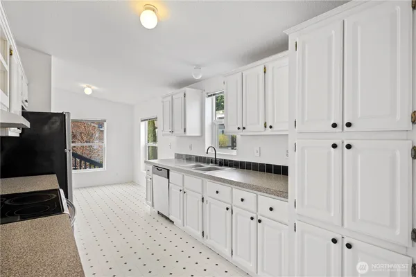 a kitchen with stainless steel appliances granite countertop a stove a sink and a white refrigerator