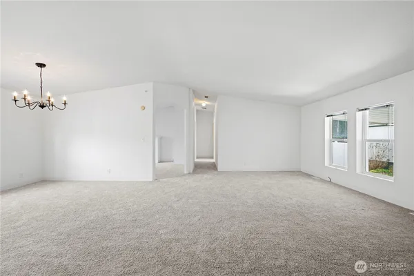 en empty room with windows and ceiling fan