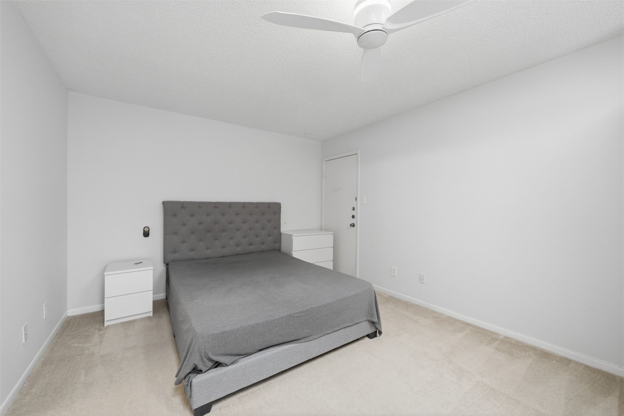 10855 Meadowglen Lane, Unit 823 Houston, TX 77042 - Photo 25 of 35 a room with a bed and a lamp on the dresser
