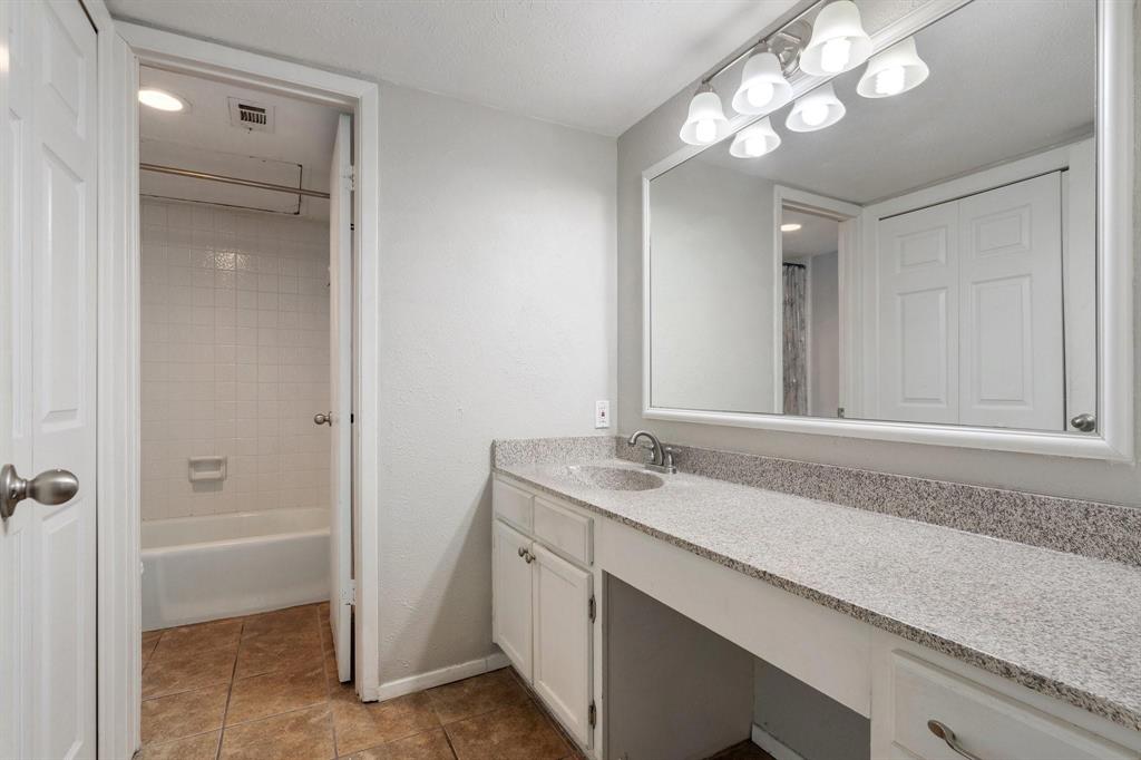 4533 North O'Connor Road, Unit 2208 Irving, TX 75062 - Photo 17 of 28 a bathroom with a granite countertop sink a large mirror and a shower