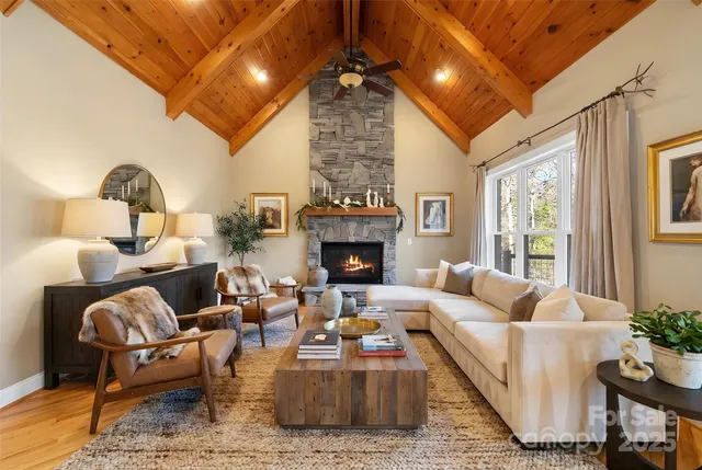 a view of an empty room with wooden floor fireplace and a window