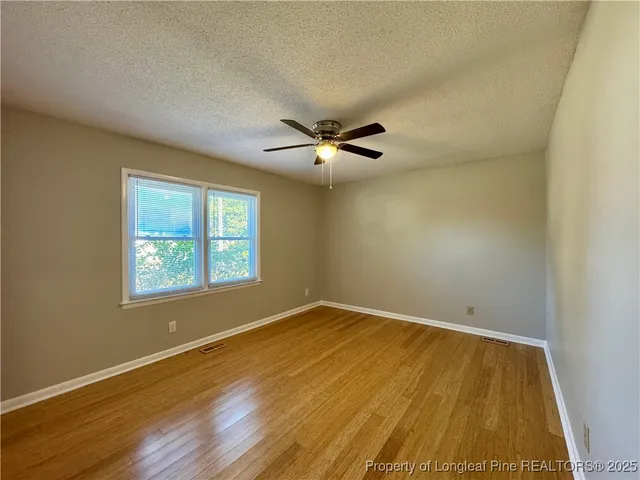 a view of room with wooden floor and windows