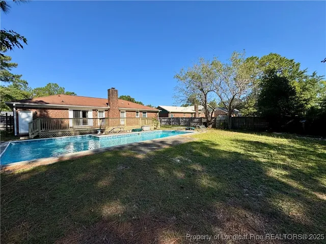 a front view of house with yard space and swimming pool