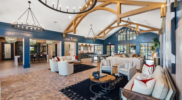 a living room with furniture a large window and a chandelier