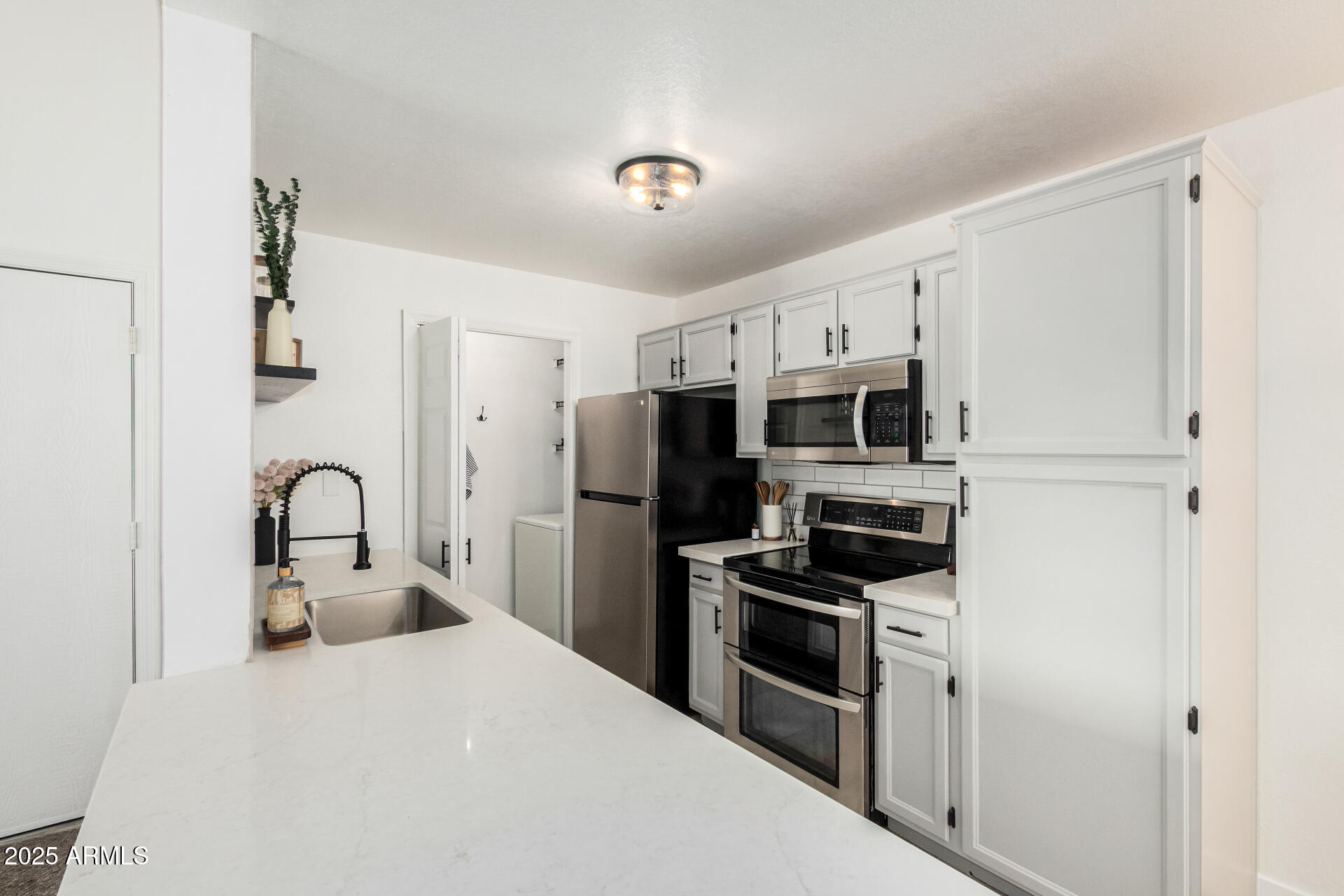 623 West Guadalupe Road, Unit 228 Mesa, AZ 85210 - Photo 4 of 14 a kitchen with stainless steel appliances a refrigerator stove and white cabinets