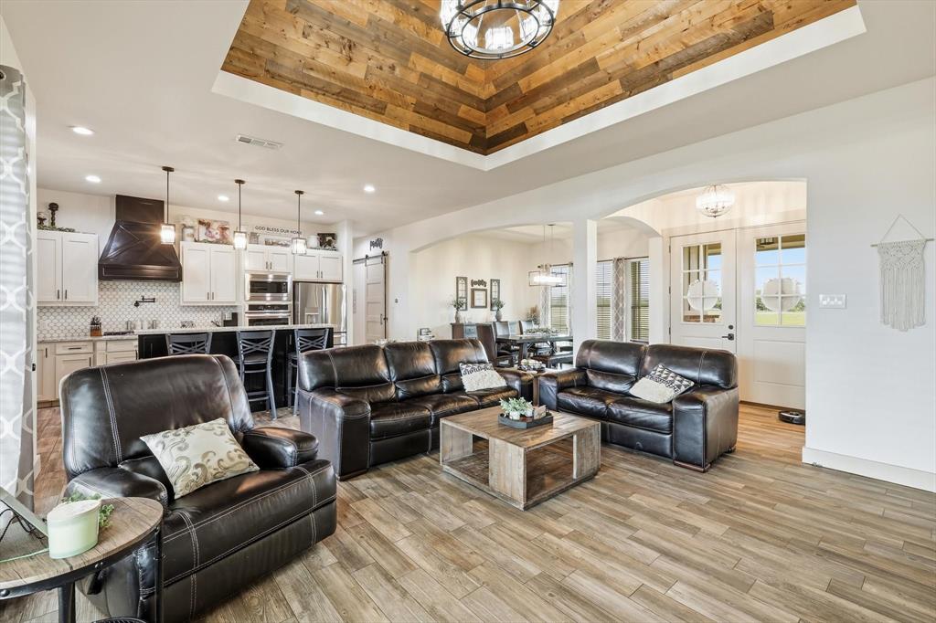 6020 Honeysuckle Road Midlothian, TX 76065 - Photo 8 of 39 Living area featuring wood-finish flooring, a recessed ceiling with wood-paneled inlay, and a chandelier