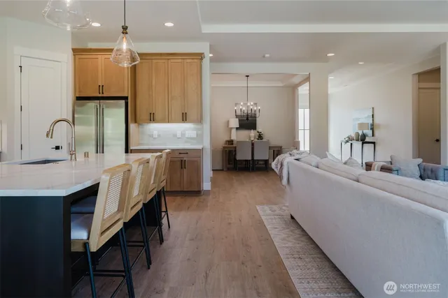 a large kitchen with kitchen island a island a stove a sink a dining table and chairs